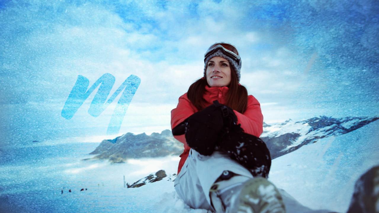 Die Rennfahrerin Cyndie Alleman macht vom Snowboarden eine Pause und blickt über die Schweizer Alpen während der Ausschnitt einfriert.